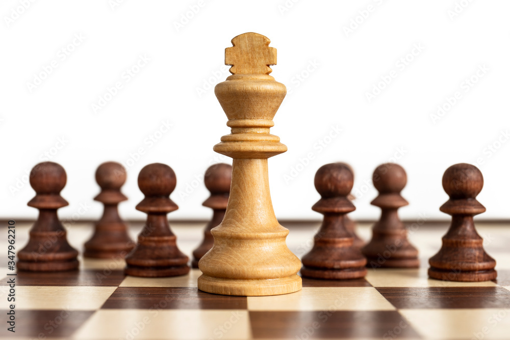 White king surrounded by black pawns. Concept picture taken in studio concerning decision making, strategy, challenge and conflict. White king surrounded by black pawns. Concept picture taken in studio concerning decision making, strategy, challenge and conflict.