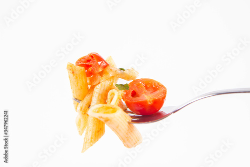 Penne with tomatoes, garlic and mozzarella on a fork on a white background
