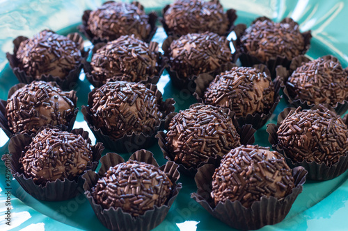 Brigadeiro. Delicious Traditional Brazilian sweet on blue plate and blue background.