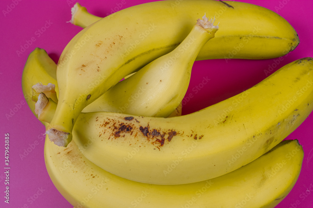yellow bananas on fuchsia background