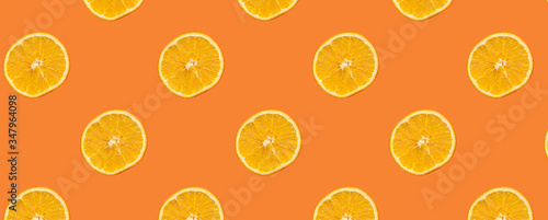 Seamless Pattern with lemon fruit slices on orange color background.