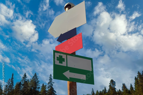 Pillar with pointers on a background of blue sky and white clouds. Free spacefor text. photo