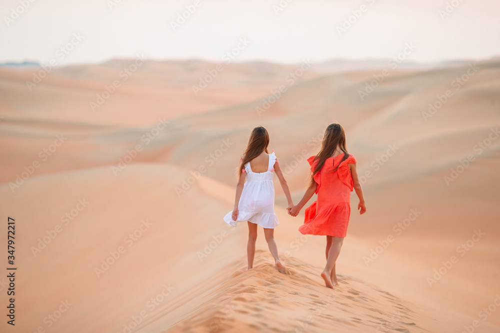 Girls among dunes in Rub al-Khali desert in United Arab Emirates