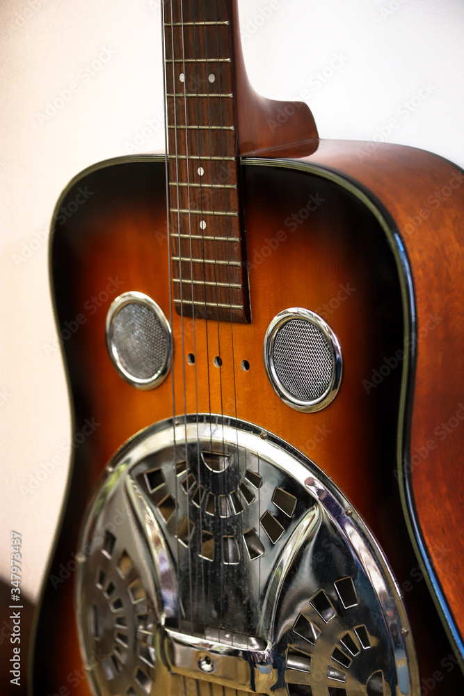 Detail of a dobro, resophonic guitar, dark brown resonator guitar. - obrazy, fototapety, plakaty 