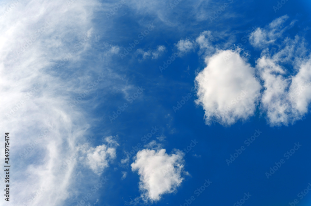Light smoky fluffy clouds against a bright blue sky. Light smoky fluffy clouds against a bright blue sky.