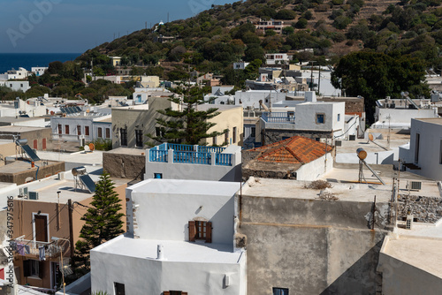 Top view of the beautiful city Mandrakion in Greece. Traditional mediterranean houses, green mountain and sea. 