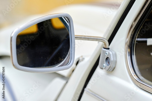 Old chrome rear mirror in classic car