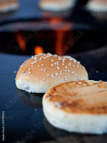 Close up of two burger buns roasting on a fire plate.