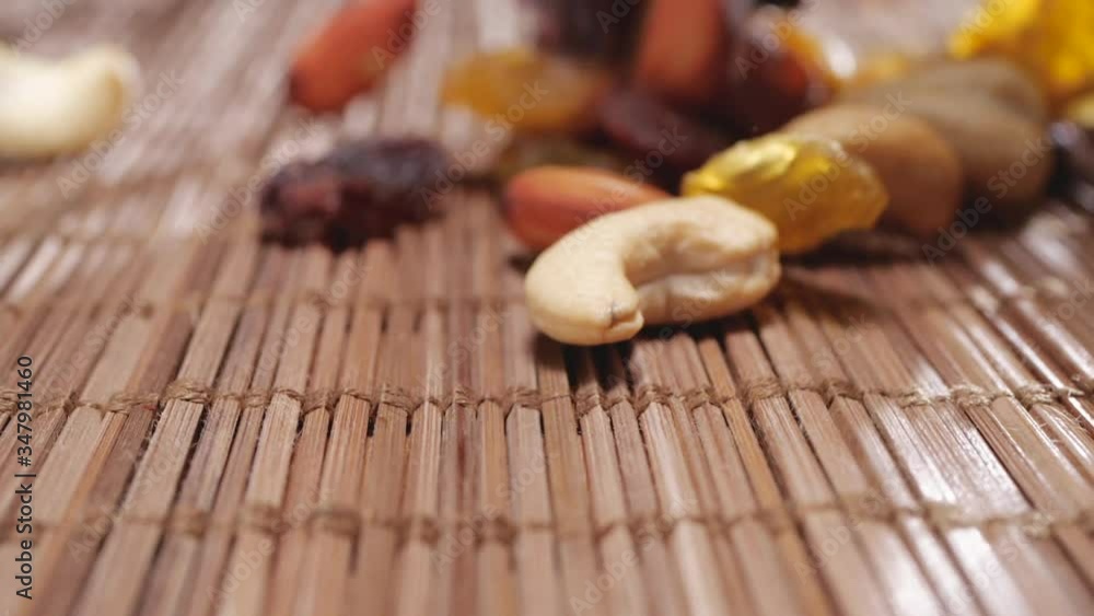 falling dried fruits in slow motion on a bamboo background, raisins ...