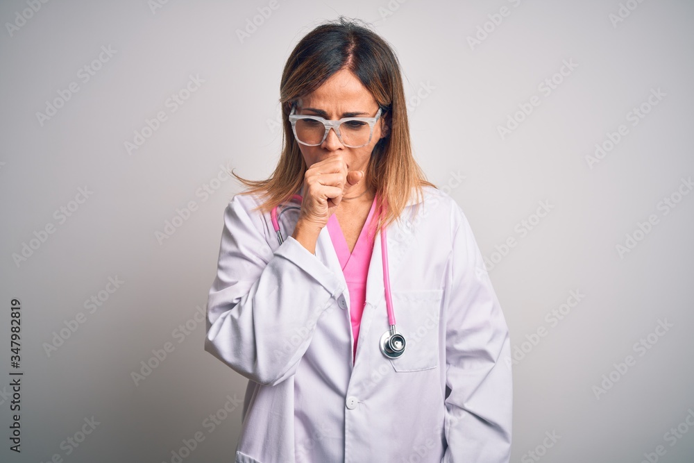 Middle age beautiful doctor woman wearing pink stethoscope over isolated white background feeling unwell and coughing as symptom for cold or bronchitis. Health care concept. Middle age beautiful doctor woman wearing pink stethoscope over isolated white background feeling unwell and coughing as symptom for cold or bronchitis. Health care concept.