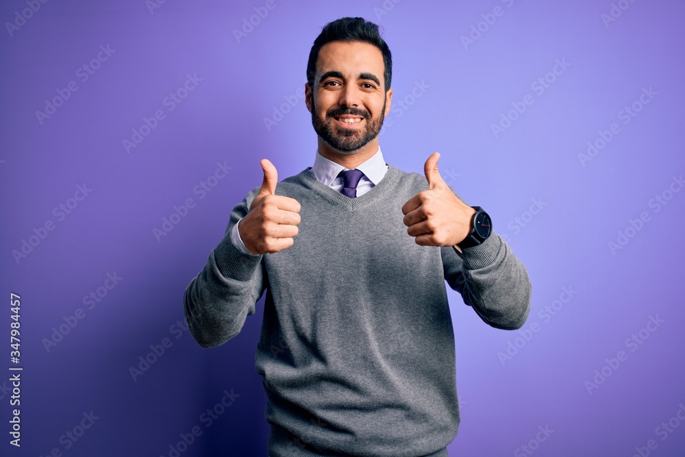 Handsome businessman with beard wearing casual tie standing over purple background success sign doing positive gesture with hand, thumbs up smiling and happy. Cheerful expression and winner gesture. Handsome businessman with beard wearing casual tie standing over purple background success sign doing positive gesture with hand, thumbs up smiling and happy. Cheerful expression and winner gesture.