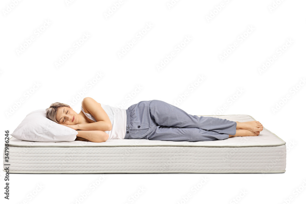 Young woman in pajamas sleeping on a comfortable mattress