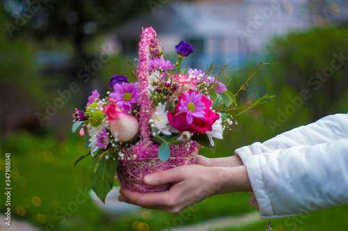 basket with flowers in the hands of a girl