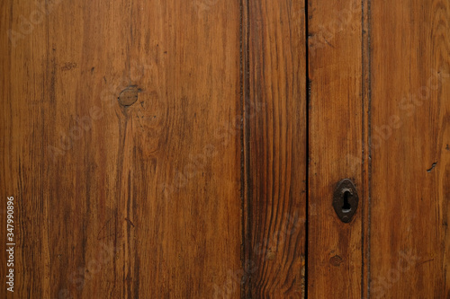 simple wooden door with a key hole, a fragment. © Daguimagery