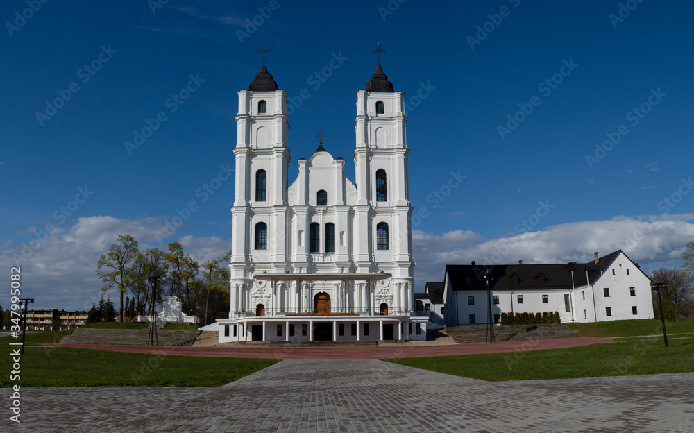Majestic Aglona Cathedral in Latvia. White Chatolic Church Basilica. Sunny Spring Day Blue Sky and White Clouds. One of the Most Important Catholic Spiritual Centers in Latvia