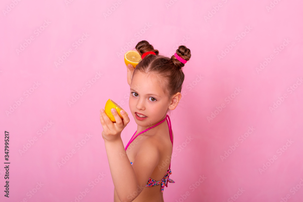 Portrait of pretty little girl holding slices of orange.