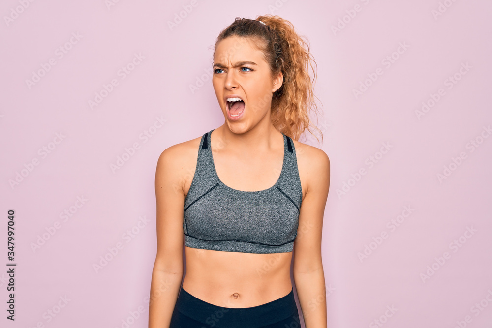 Young beautiful blonde sportswoman with blue eyes doing exercise wearing sportswear angry and mad screaming frustrated and furious, shouting with anger. Rage and aggressive concept. Young beautiful blonde sportswoman with blue eyes doing exercise wearing sportswear angry and mad screaming frustrated and furious, shouting with anger. Rage and aggressive concept.