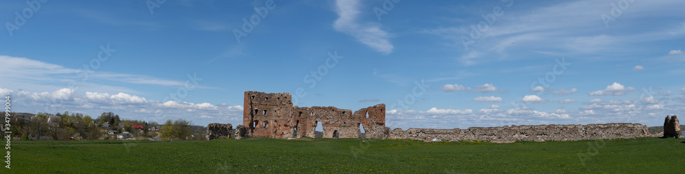 Panoramic View of the Ludza Medieval Castle Ruins on a Hill Between Big Ludza Lake and Small Ludza Lake. The Ruins of an Ancient Castle in Latvia. Sunny Spring Day.
