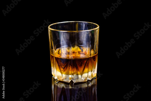 Glass of whiskey isolated on the black background