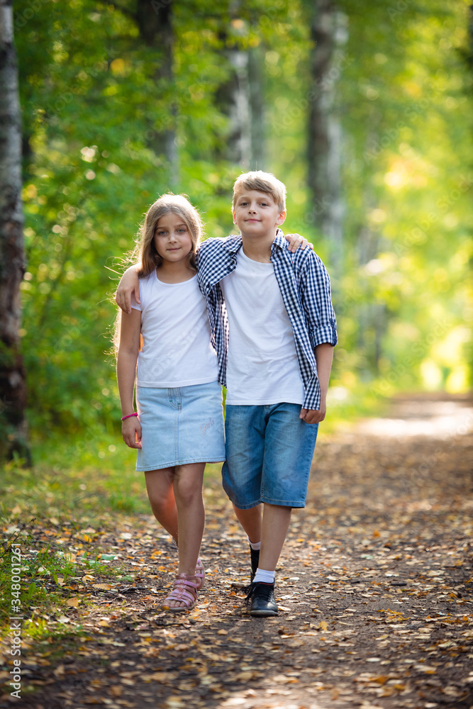 First love. Little boy and girl holding hands and smiling while walking outdoors in park First love. Little boy and girl holding hands and smiling while walking outdoors in park