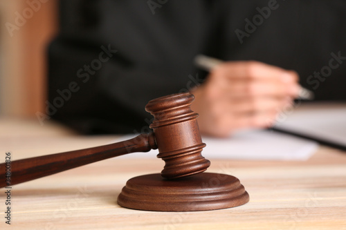 Gavel on table of female judge in courtroom, closeup