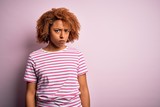 Young beautiful African American afro woman with curly hair wearing casual striped t-shirt skeptic and nervous, frowning upset because of problem. Negative person.