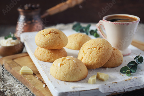 Coconut cookies with white chocolate and  cup of coffee photo