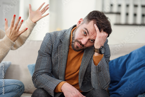 Foto Nervous young man trying to doesn't listen to his girlfriend in the bedroom
