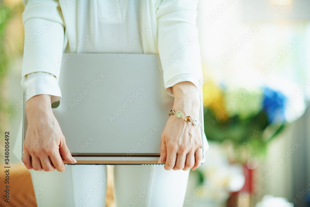 happy woman in living room in sunny day holding laptop happy woman in living room in sunny day holding laptop