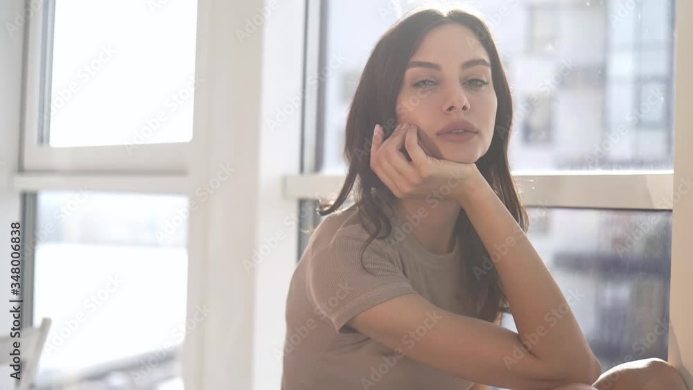 A sexy model poses at sunset in her apartment with panoramic windows. emotion evening mood calm, outside the city and the Dnieper river. A sexy model poses at sunset in her apartment with panoramic windows. emotion evening mood calm, outside the city and the Dnieper river.