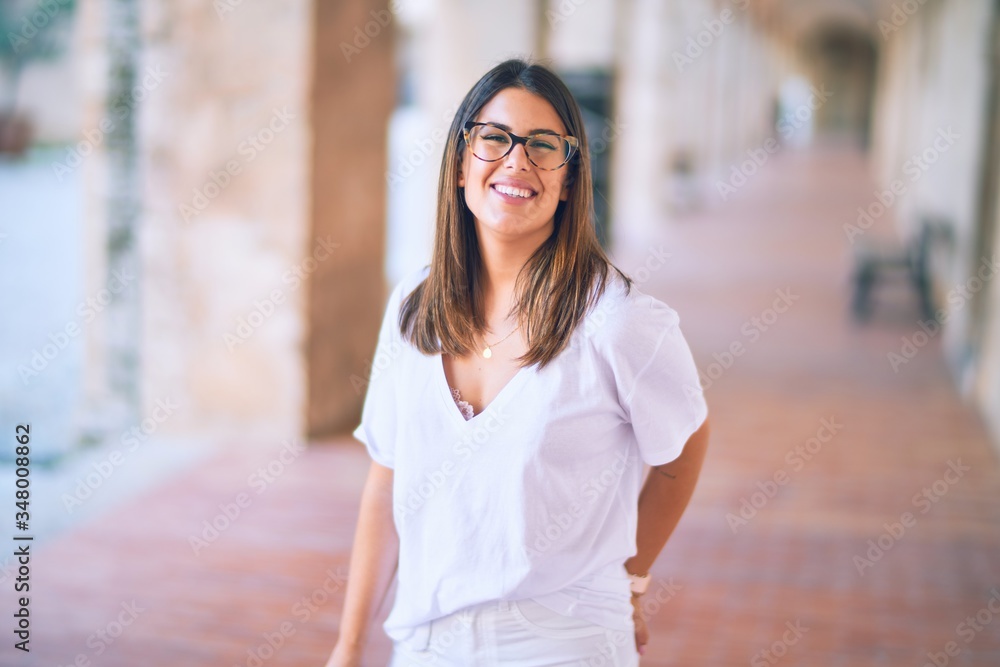 Young beautiful woman smiling happy and confident. Standing with smile on face at the town street