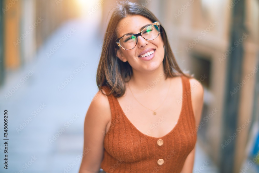 Young beautiful woman smiling happy and confident. Standing with smile on face at the town street Young beautiful woman smiling happy and confident. Standing with smile on face at the town street