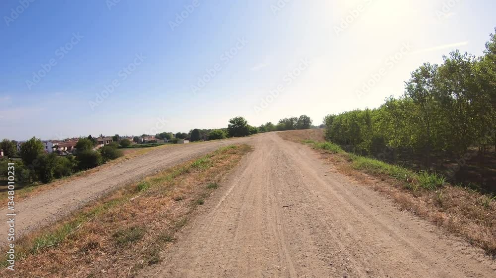 dirt road on the Embankment along the Po river at Sartorona village, municipality of Pieve Porto Morone, province of Pavia, Lombardy, Italy