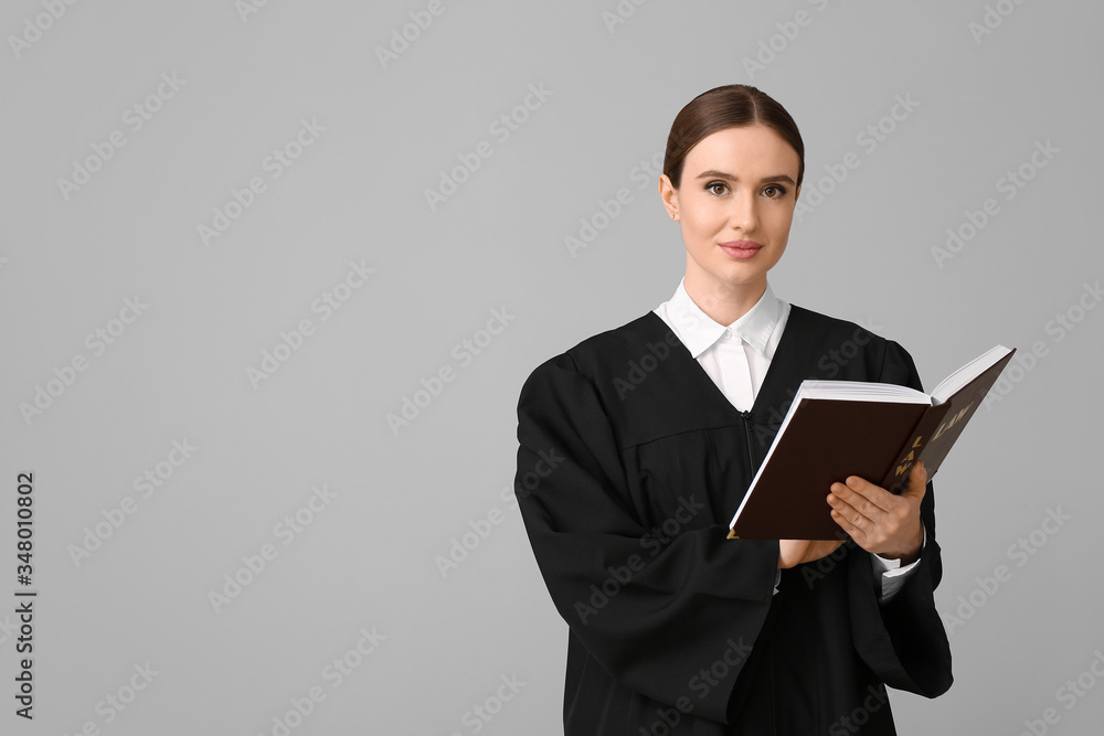 Female judge with book on light background Female judge with book on light background