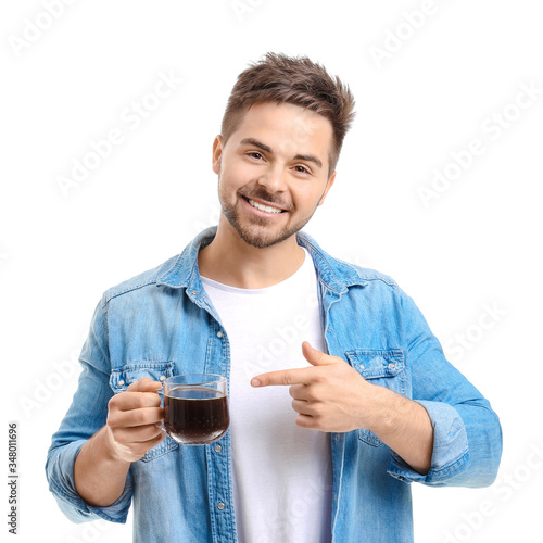 Young man with cup of hot coffee on white background