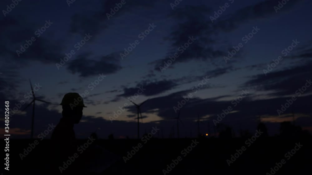 Man engineer working and holding the report at wind turbine farm Power Generator Station on mountain,Thailand people
Man engineer working and holding the report at wind turbine farm Power Generator Station on mountain,Thailand people