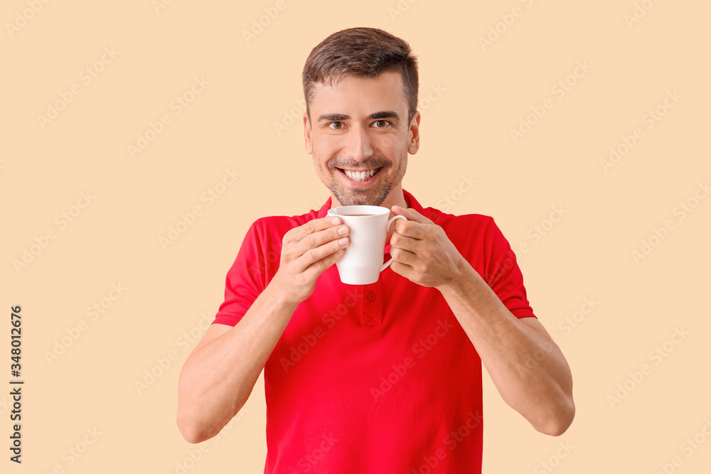 Young man with cup of hot coffee on color background Young man with cup of hot coffee on color background
