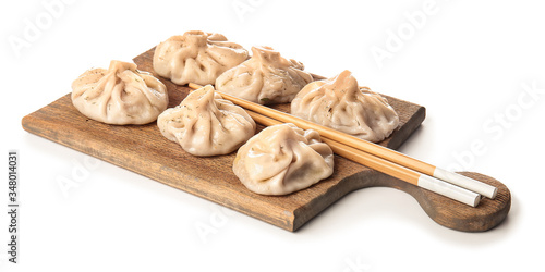 Board with tasty dumplings on white background