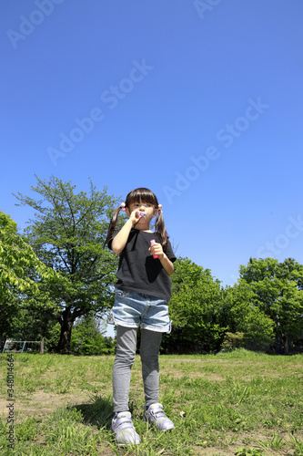 シャボン玉で遊ぶ幼児(5歳児)と青空 © ziggy