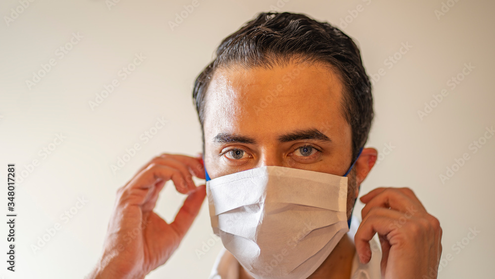 Latin man putting on face mask Latin man putting on face mask