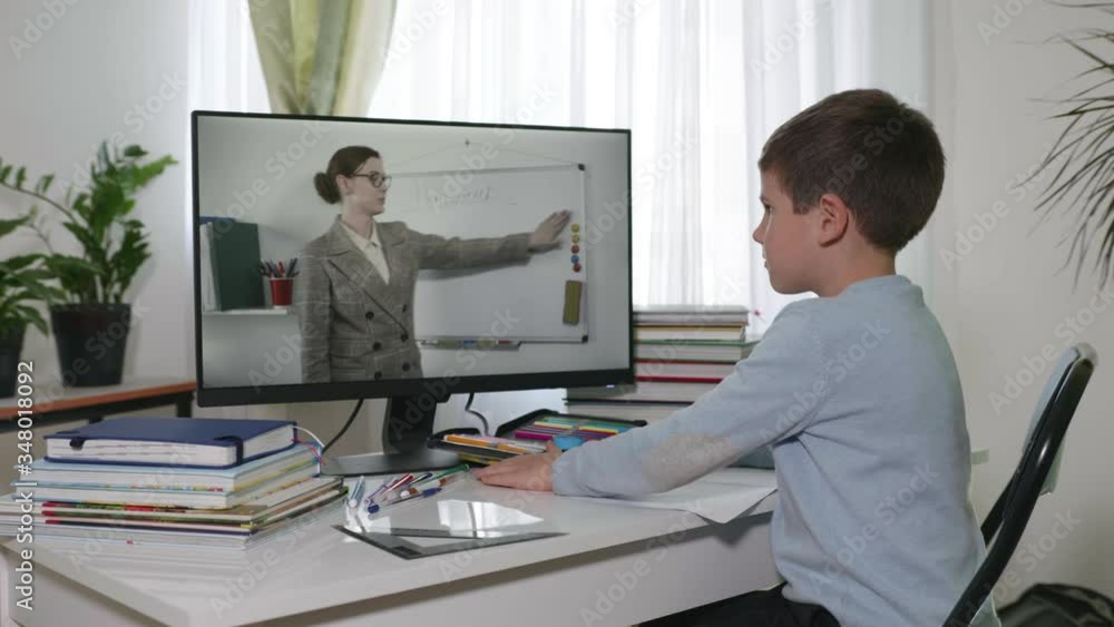 distance learning, homework boy watching a video broadcast of a lesson where a teacher explains a lesson in video communication during a pandemic distance learning, homework boy watching a video broadcast of a lesson where a teacher explains a lesson in video communication during a pandemic