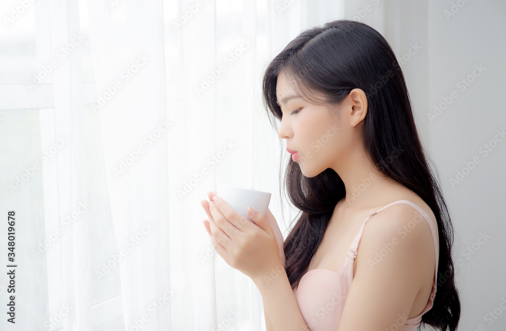 Beautiful young asian sexy woman in underwear drinking coffee near windows in the morning, girl with seductive figure fit drinking beverage for relax and resting after wake up, lifestyle concept. Beautiful young asian sexy woman in underwear drinking coffee near windows in the morning, girl with seductive figure fit drinking beverage for relax and resting after wake up, lifestyle concept.