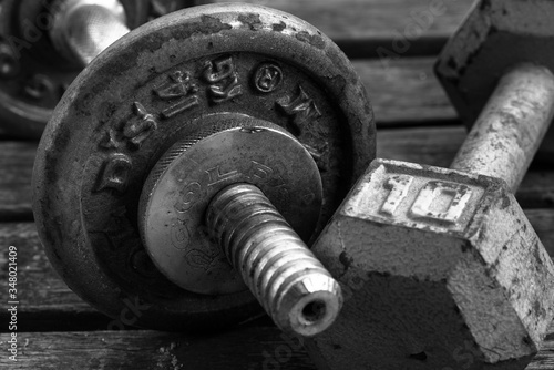 old rusty dumbbells unused in black and white