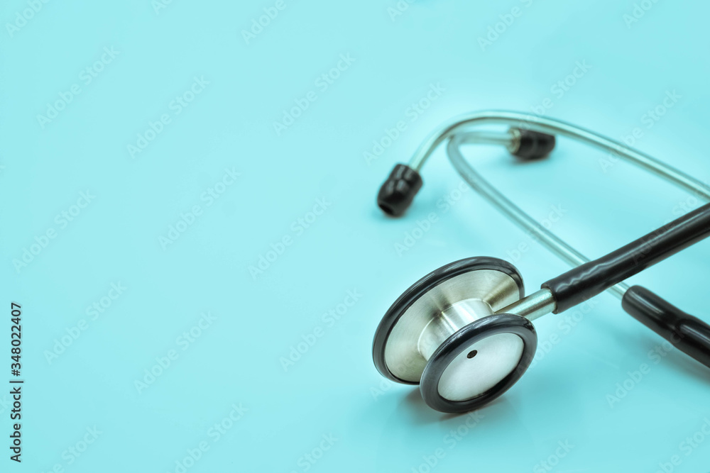Close-up of Black stethoscope of doctor for checkup on light blue background. Stethoscope equipment of medical use to diagnose hear sound. Health care and cardiology concept with copy space. Close-up of Black stethoscope of doctor for checkup on light blue background. Stethoscope equipment of medical use to diagnose hear sound. Health care and cardiology concept with copy space.