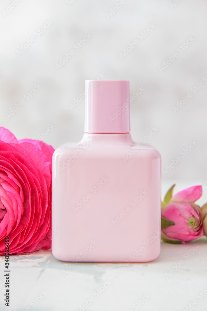 Bottle of perfume with flowers on light background Bottle of perfume with flowers on light background