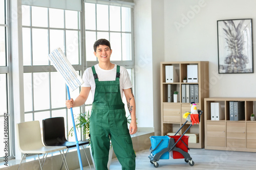 Male janitor mopping floor ...