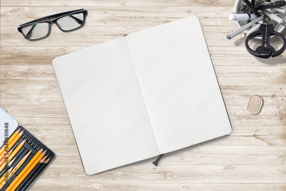 illustration of opened sketchbook with blank pages and workplace objects on wooden desk. illustration of opened sketchbook with blank pages and workplace objects on wooden desk.