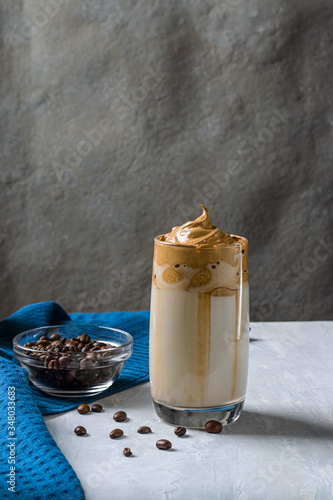 Cold trendy drink of Korean dalgon coffee on a dark background. Delicious and popular coffee in trend photo