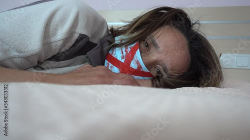 4K Lockdown isolation selfies - Depressive woman on bed in blood-stained mask
 photo