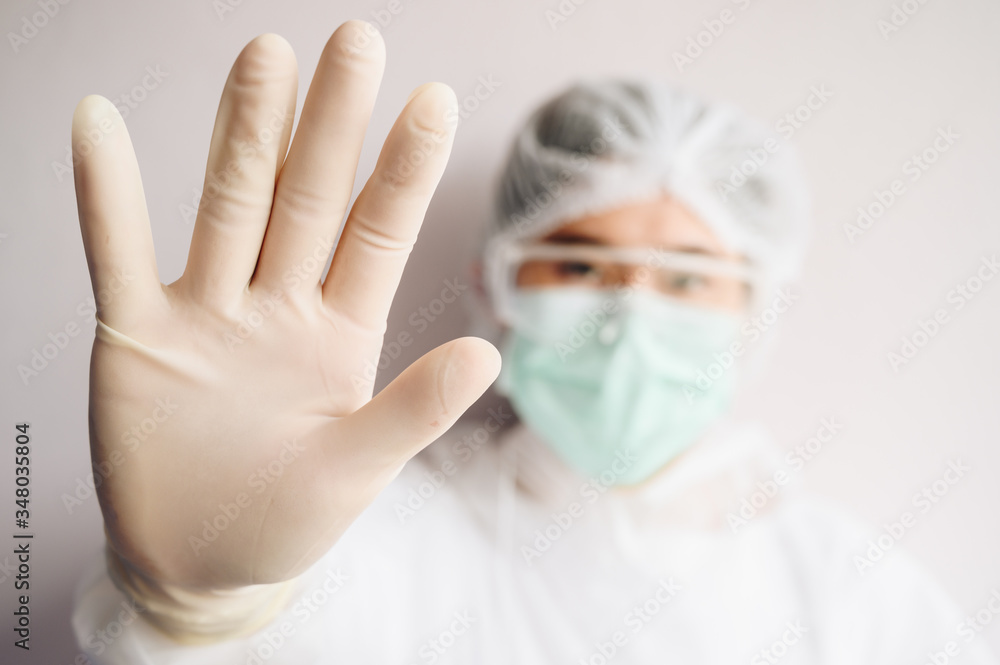 Nurse wearing PPE suit for protect virus and show stop hand gesture for social distancing. Social distancing is the physical space between people to avoid spreading illness. Nurse wearing PPE suit for protect virus and show stop hand gesture for social distancing. Social distancing is the physical space between people to avoid spreading illness.